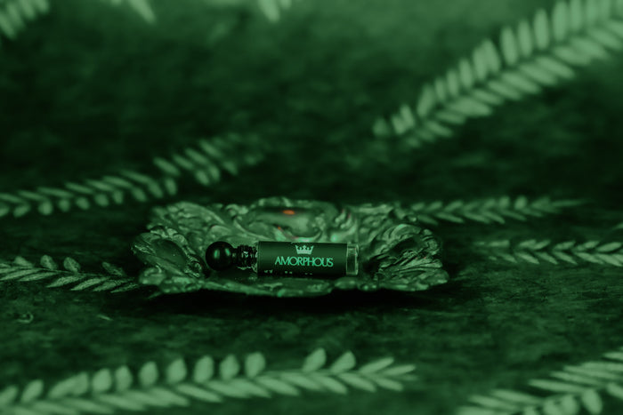 Amorphous perfume sample on a textured green surface