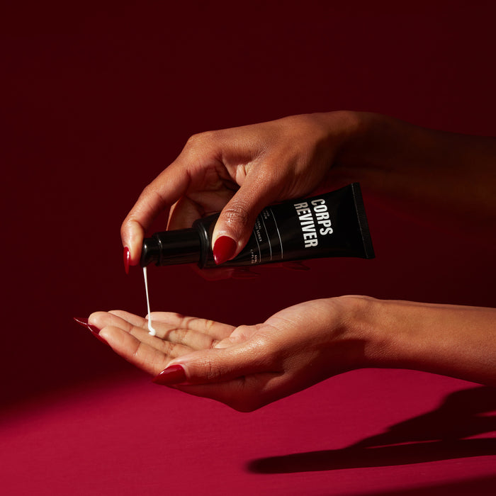 Hands applying Corps Reviver hand serum