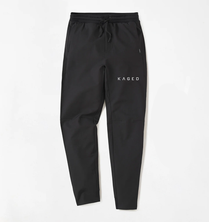 Front view of Kaged x UNRL Apex training pants in black, tapered fit with drawstring waistband, zip pockets, KAGED logo #color_black
