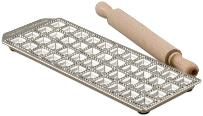 A mini square ravioli maker with 44 forms, made of aluminum with an enameled steel base and a wooden rolling-pin.