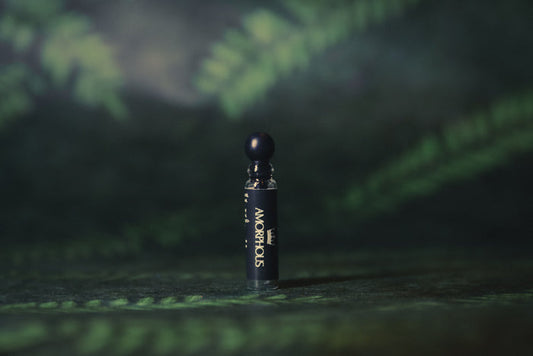 perfume sample with a cap on a dark green textured background