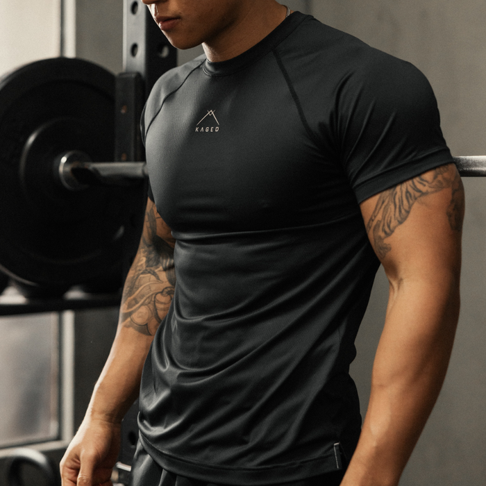 Close up of Ascent Performance Tee in black showing slim athletic fit, moisture wicking fabric and Kaged chest logo