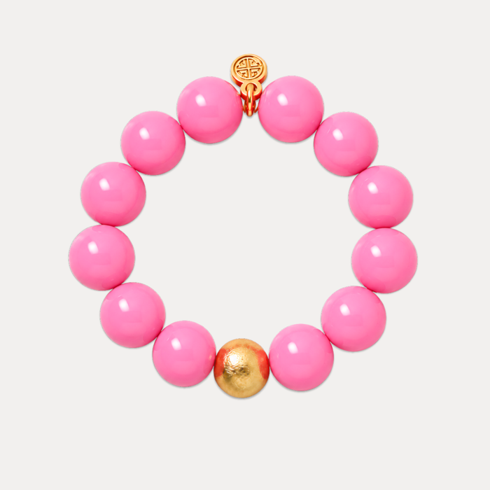 a pink beaded bracelet with a gold ball