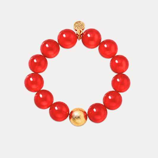 a red beaded bracelet with a gold bead