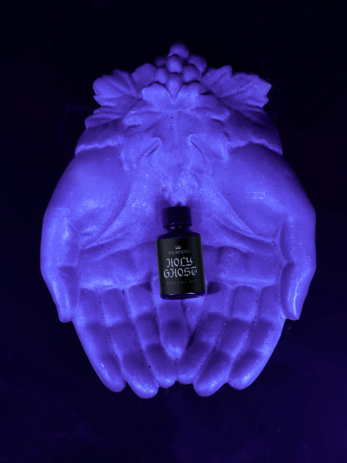Bottle labeled 'Holy Ghost' on glowing hands against a dark background