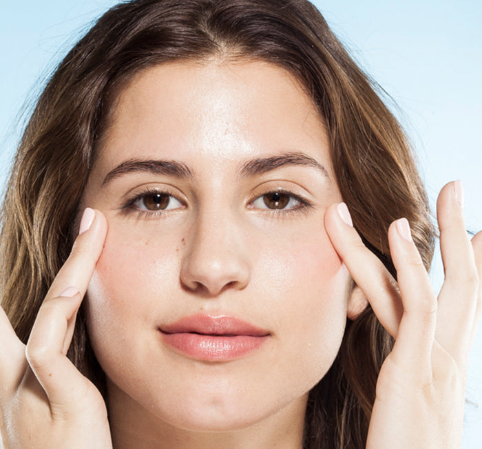 Woman gently applying Crow Catcher® Eye Transforming Serum | Farmhouse Fresh around her eyes, showcasing smooth, radiant skin and a natural skincare routine.