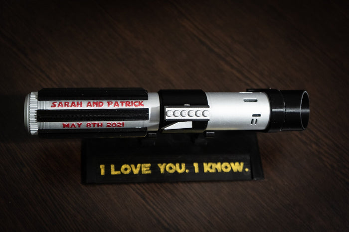 Personalized Star Wars inspired bridal bouquet holder shaped like Darth Vader's lightsaber with custom wedding date and names.