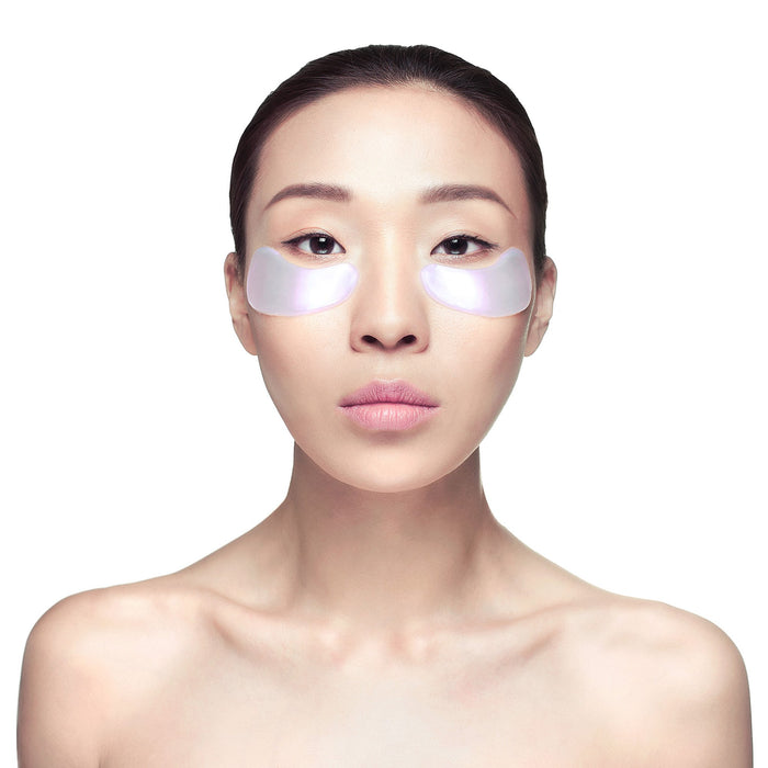 Young woman with smooth skin wearing Diamond Radiance Eye Mask - Single | Knesko under her eyes for skincare and wellness recovery.