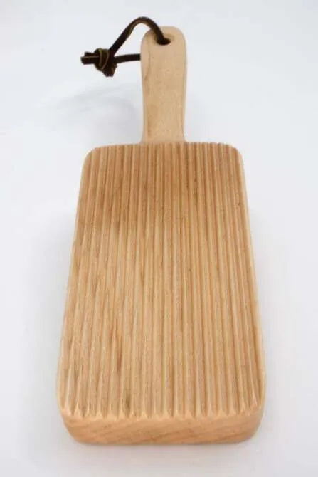 A wooden gnocchi paddle with a flat rectangular board and a long handle,  displayed against a white background.