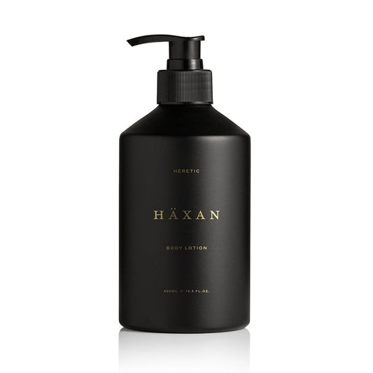A matte black pump bottle of Häxan Heretic Body Lotion, featuring gold lettering on the front, set against a clean white background.