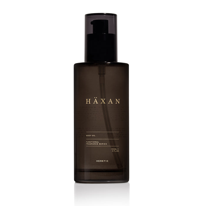 A dark black translucent pump bottle of Häxan Body Oil with a black cap, centered on a white background.