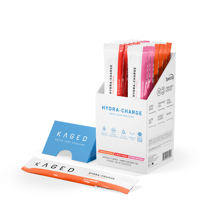 Three-quarter view of Hydra-Charge stick box showcasing 15 single-serve hydration packets in orange, fruit punch, and pink with one packet laid in front on white background #flavor_Variety Box (Orange Mango, Fruit Punch, Pink Lemonade)