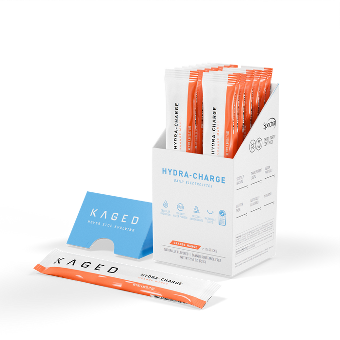 Three-quarter view of Hydra-Charge Stick Box showcasing Orange Mango hydration stick packs (15ct) with one stick laid in front on white background #flavor_orange mango