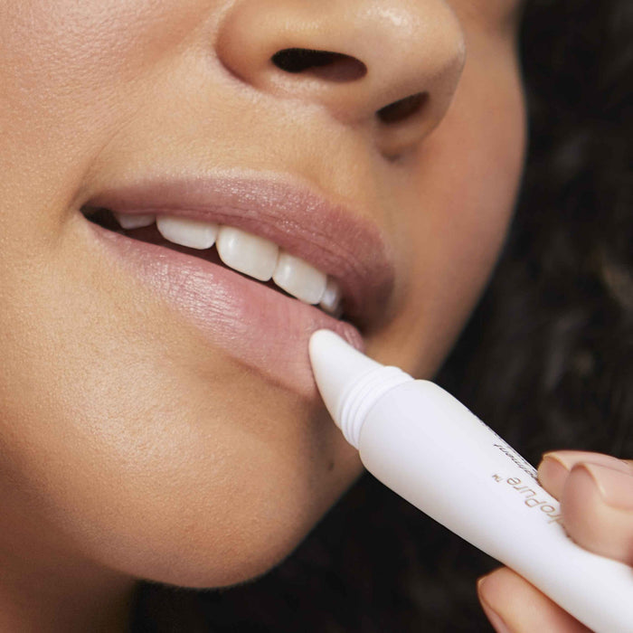 Close-up of a person applying HydroPure Hyaluronic Acid Lip Treatment | Jane Iredale to smooth and hydrate lips, promoting skincare and lip wellness.