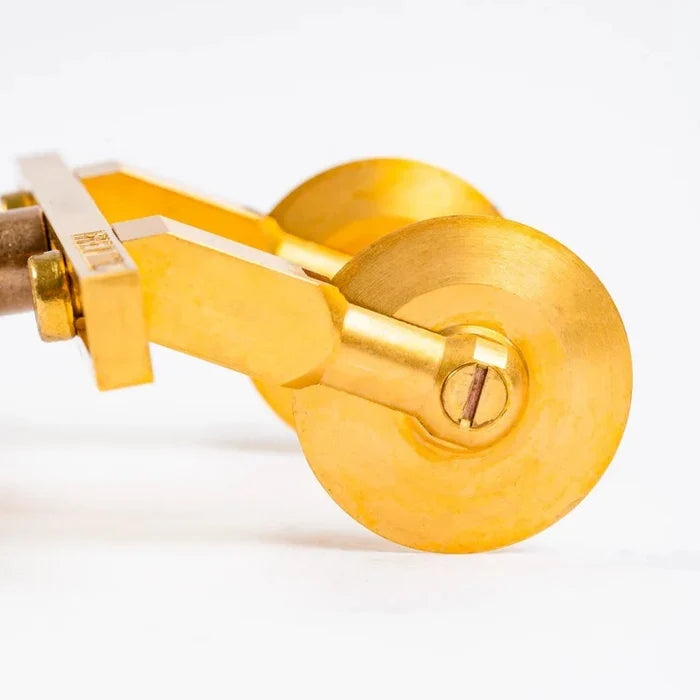 A professional adjustable ravioli cutter with two smooth wheels made of brass and a natural wood handle.