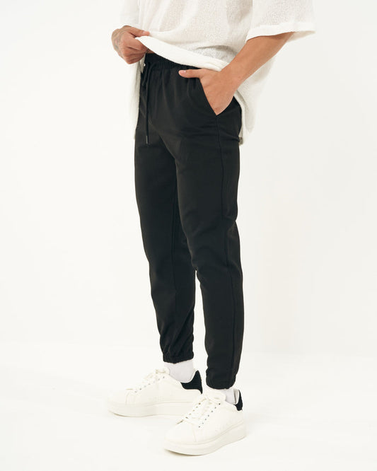 Martin Valen men's slim-fit black casual jogger, side mid-body view with hand in pocket and visible drawstring