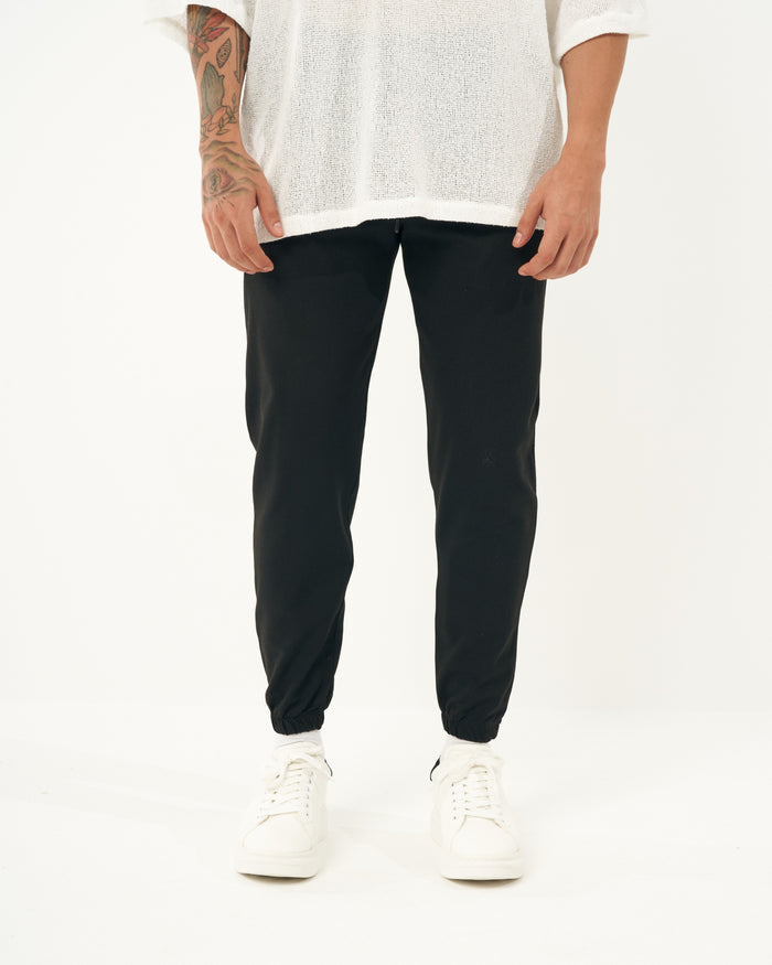 Martin Valen men's slim black jogger, three-quarter view showing full leg and white sneakers