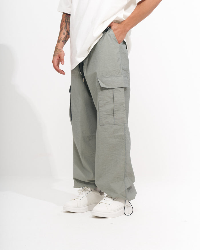 Martin Valen men's wide-leg cargo jogger in light sage green, close-up side view highlighting flap cargo pocket and wide cut