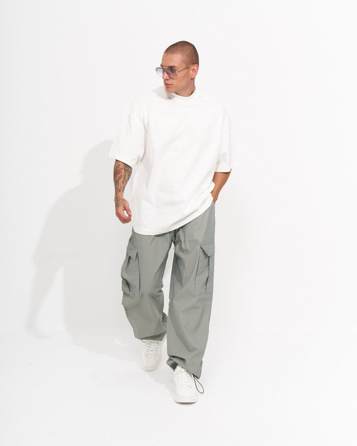Martin Valen men's parachute fabric wide-leg cargo jogger in light grey-green, three-quarter standing view