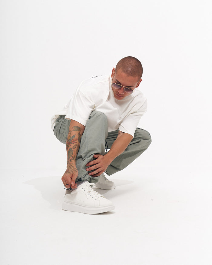 Martin Valen men's wide-leg cargo jogger in light grey-green walking, full-length view showing cargo pockets
