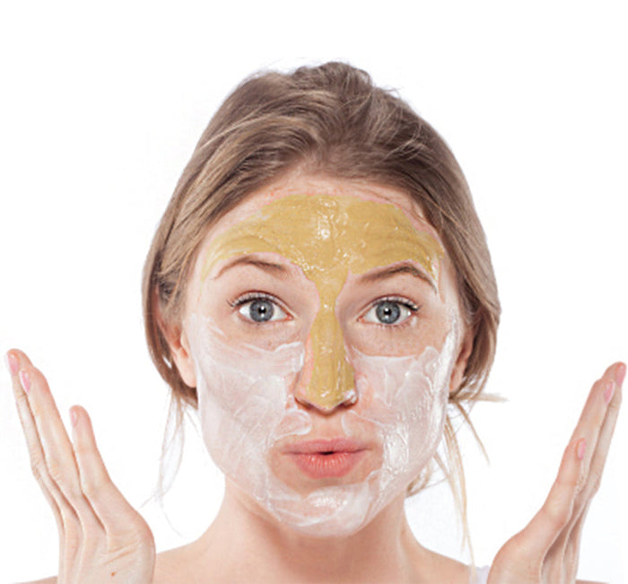 Young woman with a layered face mask applying Mighty Tighty® Turmeric & Banana Tightening Mask | Farmhouse Fresh, showcasing skincare and wellness.