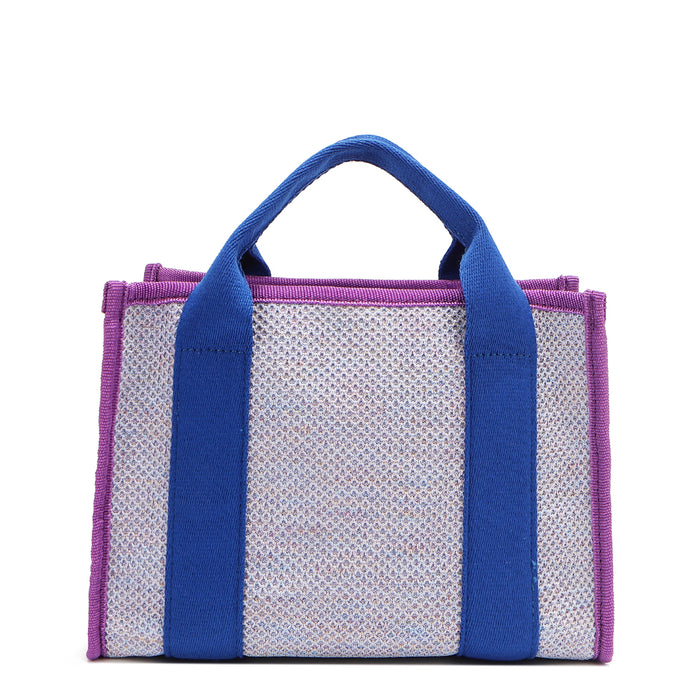 Back view of the Nodu Nadu small canvas Marley tote Bag in lavender. Accented with bold electric blue straps and a gorgeous purple trim, this canvas features a subtle metallic shimmer that hits the light whenever you walk for a head-turning detail.