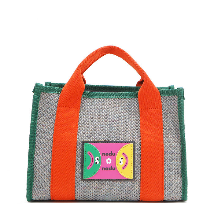 With its effortless slouchy silhouette and striking color-block trim, the Nodu Nadu small Marley tote in Gray is anything but ordinary. The real showstopper? Its canvas fabric, woven with rainbow metallic stitching that catches the light just right—adding a dreamy shimmer and a touch of everyday magic to your look!