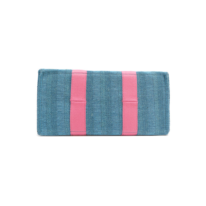 Rectangular bottom angle of the Nodu Nadu Sawyer Bag in Blue with baby pink webbed strap details. Made of durable canvas for long-lasting style.