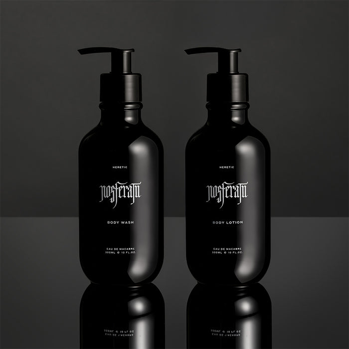 Two black bottles of Heretic Nosferatu body wash and lotion on a reflective surface with a dark background.