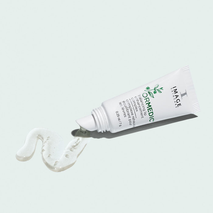 Tube of ORMEDIC lip enhancement complex | IMAGE Skincare with a smooth, clear gel product partially squeezed out on a light background, emphasizing skincare and lip care.