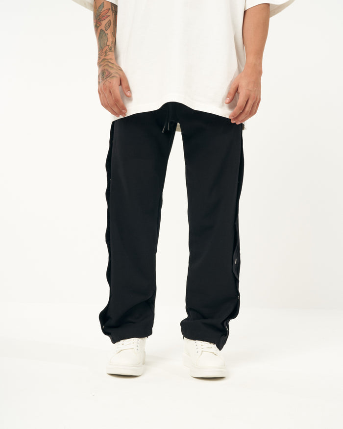 Martin Valen oversized black baggy jogger front-mid view showing drawstring waist and press-stud side placket