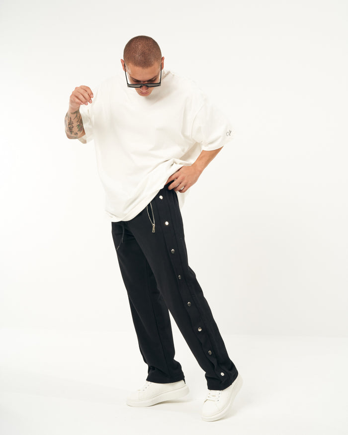 Martin Valen oversized black baggy jogger worn by model, front view showing side press studs and straight leg
