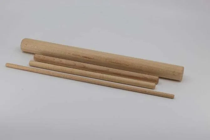 Wooden six piece pasta board set showing four wooden dowels on white background