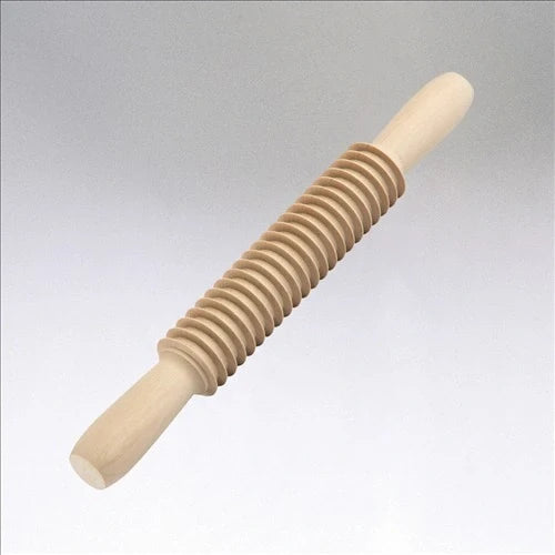 Wooden rolling pin with a ribbed design on a light gray background