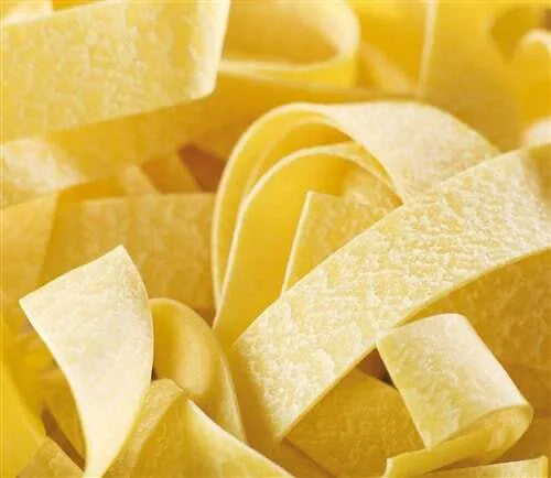 A beige wooden pasta cutter with a rolling pin shape, designed for cutting Pappardelle pasta.