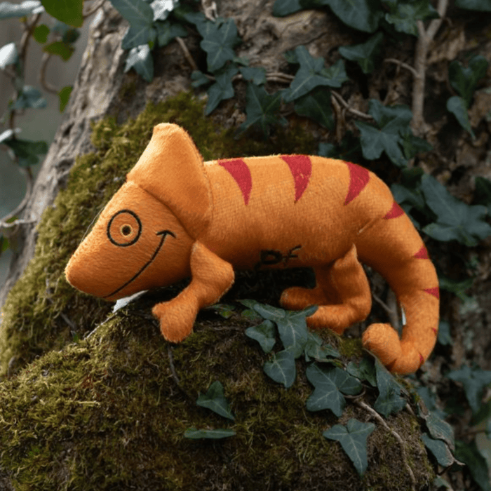 Orange plush Chameleon Cat toy with red stripe and eye and smile stitch details outside on a tree.