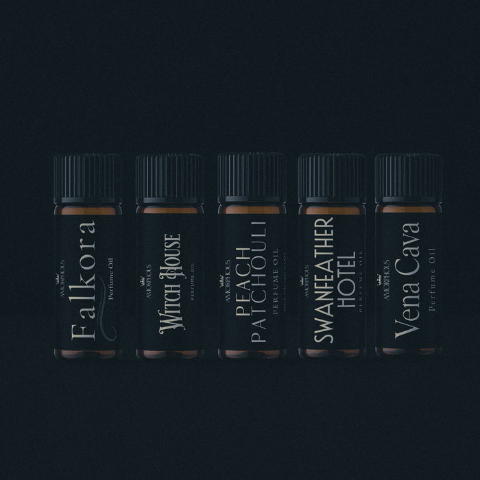 Five black perfume bottles with labels on a dark background
