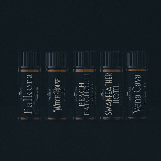 Five black perfume bottles with labels on a dark background