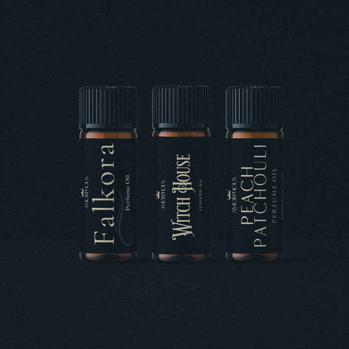 Three bottles of artisan perfume oil on a black background