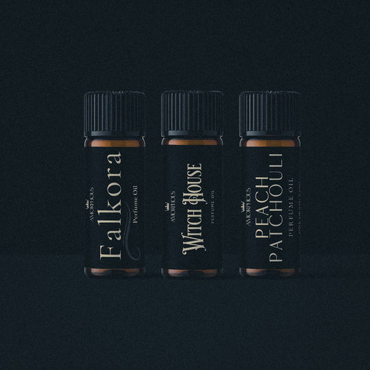 Three bottles of artisan perfume oil on a black background