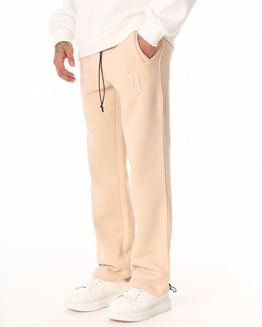 Martin Valen oversized beige jogger shown side view with black drawstring and embroidered V logo