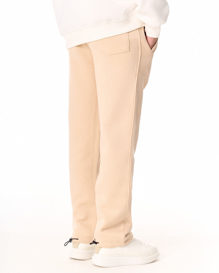 Martin Valen V‑Sharp beige jogger side view, hand in back pocket and visible seam detail