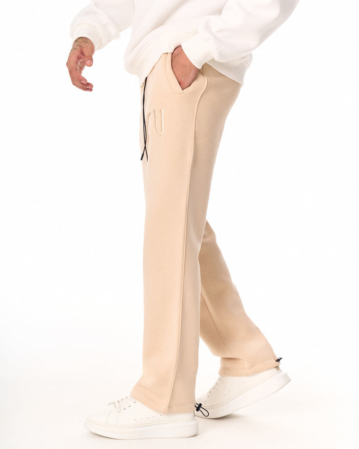 Martin Valen V‑Sharp oversized beige jogger, side view showing hand in pocket and black drawcord