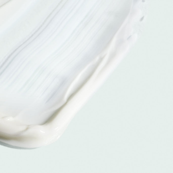 Close-up of creamy white moisturizer texture spread smoothly, representing VITAL C hydrating intense moisturizer | IMAGE Skincare for skincare and hydration.